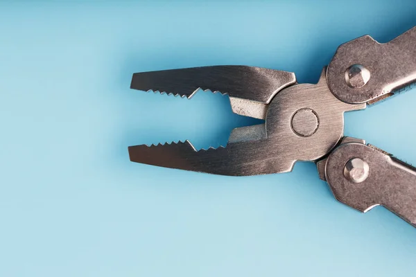 The multitool multi-function tool hovers on a blue background. The concept of an expanded multi-tool with free space. Clipping path included isolate