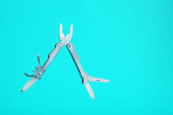 The multitool multi-function tool hovers on a blue background. The concept of an expanded multi-tool with free space. Clipping path included isolate