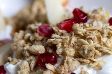Nar ve yoğurt üzerine müsli yakın plan.