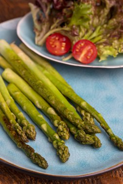 Mavi tabakta ızgara yeşil kuşkonmaz.