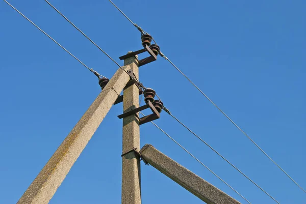 Elektriska ledningar på en konkret stöd mot en blå himmel. — Stockfoto