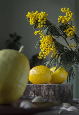 Karanlık bir arka planda limonlar ve parlak bir buketle dolu bir hayat