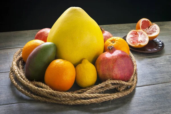 Fruits are tied with a decorative palm rope and lie on a gray ru — Stock Photo, Image