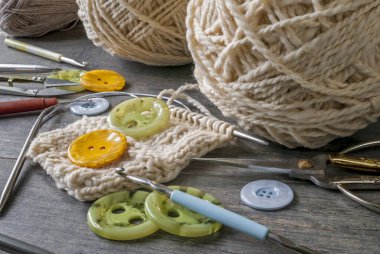 İlgili aletlerle el örgüsü iplikleri - makas, kanca, düğmeler, kırsal bir masada duran örgü iğneleri.