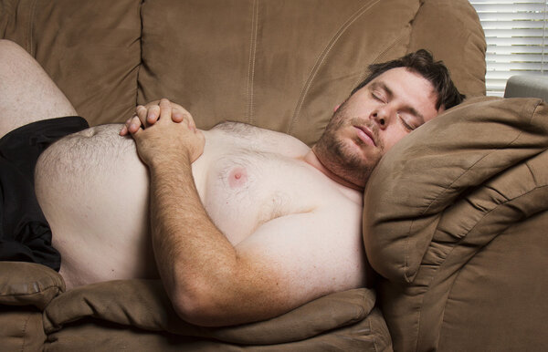 Толстяк, спящий на диване.
