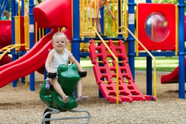 Çocuk oyun alanında eğleniyor ve gülümsüyor