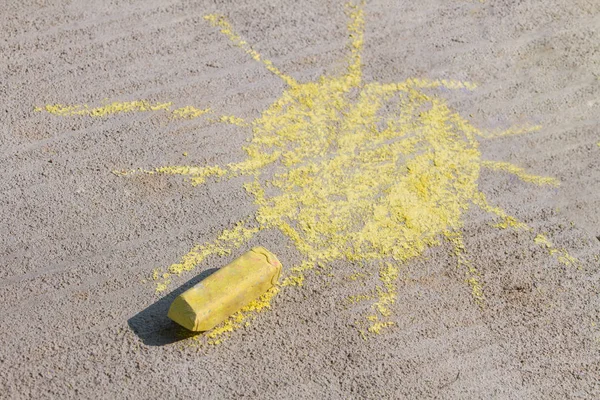 bright yellow sun that has been drawn with chaulk on the sidwalk