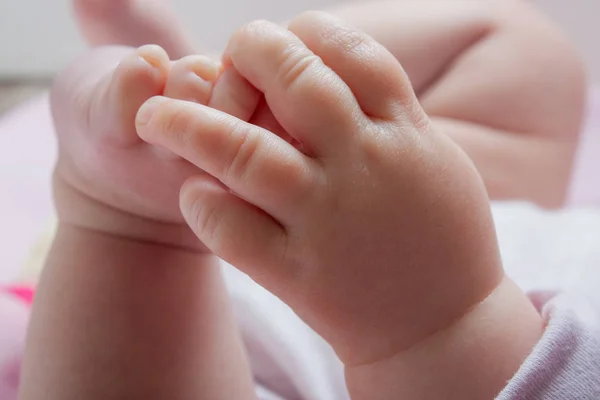 Una Niña Pequeña Agarra Los Dedos Los Pies Con Mano —  Fotos de Stock