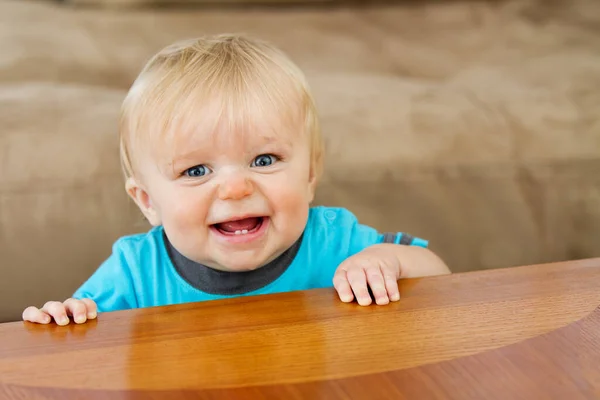 His toothy grin is there as he learns to stand