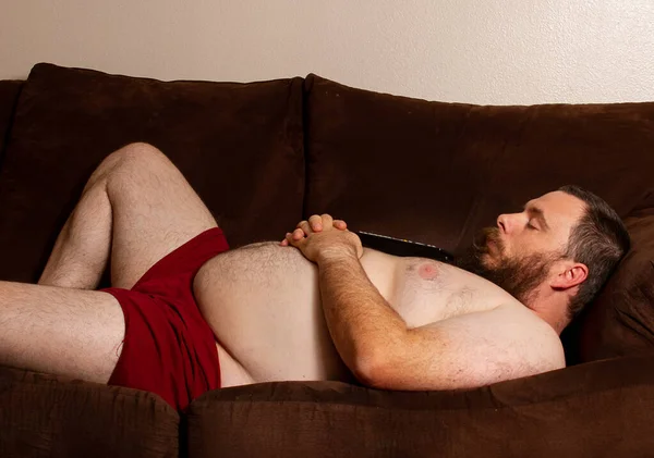 Толстяк спит на диване после просмотра телевизора — стоковое фото