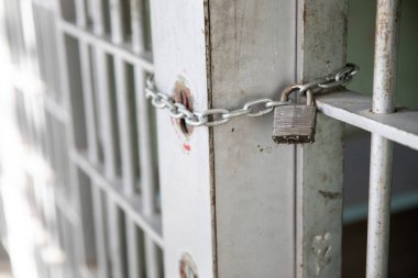 Kapı metal bir kilit ve zincir ile kapalı tutulur.