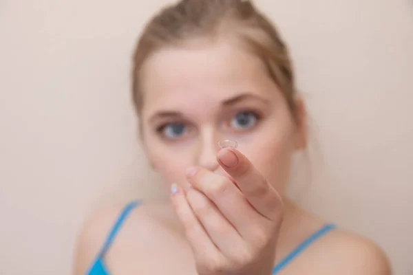 Jovencita sosteniendo una lente de contacto en su dedo — Foto de Stock