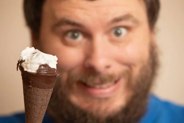 Homem sorrindo no fundo de um cone de sorvete parcialmente comido — Fotografia de Stock