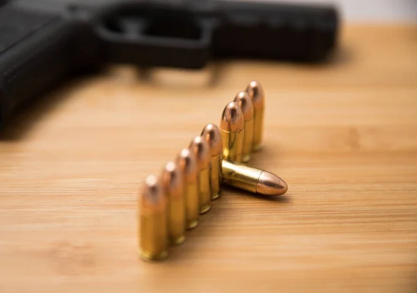 Balles de 9mm dans une rangée avec un pistolet — Photo