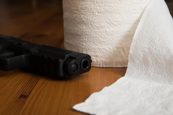 Pose de pistolet à côté de papier toilette — Photo