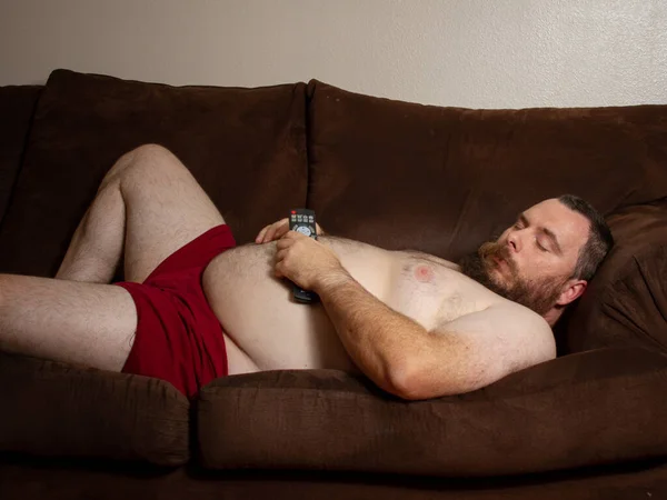 Человек изолируется, спит на диване — стоковое фото