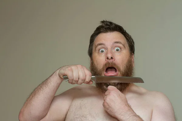 Człowiek obcinający włosy ostrym nożem — Zdjęcie stockowe