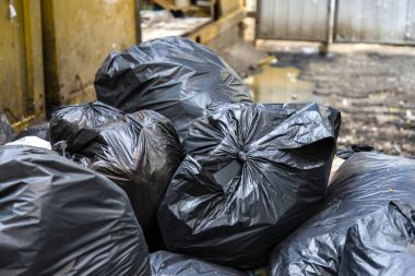 Siyah çöp torbaları ve bulanık kirli ıslak zemin arka plan