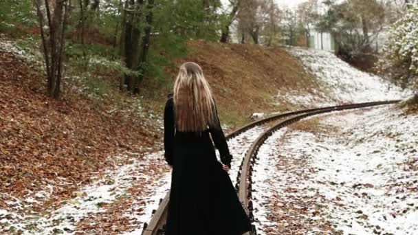 Женщина ходит по железнодорожным путям — стоковое видео