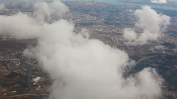Blick aus dem Bullauge eines Flugzeugs. Wolken über Lissabon. — Stockvideo