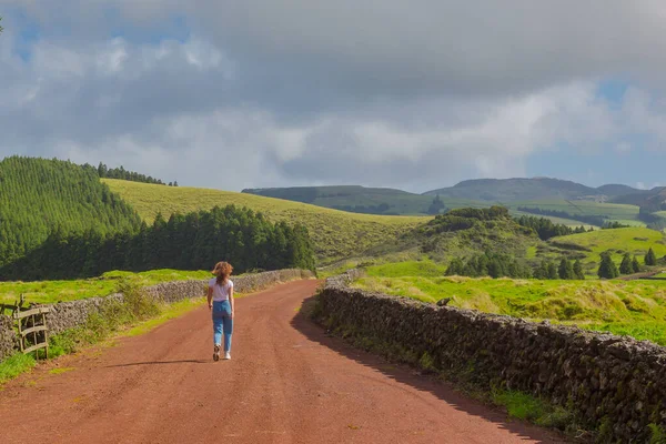 Egy fiatal nő sétál a vidéki úton. Kék égboltos mezők. Terceira — Stock Fotó