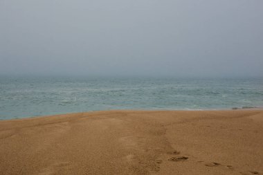 Deniz ve kumlu sahil yoğun siste, sonbahar günü