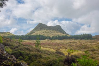 Tarlaların üzerinde çifte Tepe. Mavi gökyüzü ve bulutlarıyla Azores 'teki Terceira Adası.