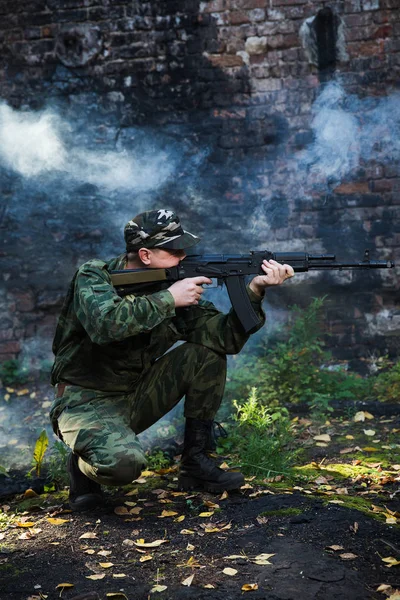 Żołnierz lub Milicjant w kamuflażu karabin szturmowy Ak walce w ruiny — Zdjęcie stockowe