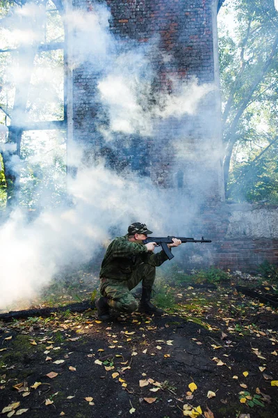 Soldaat of burgerwacht in camouflage met aanval geweer Ak gevechten in ruïnes — Stockfoto