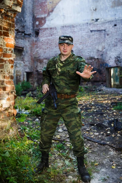 Soldado mostrando señal de stop a mano en ruinas. Detener concepto . — Foto de Stock