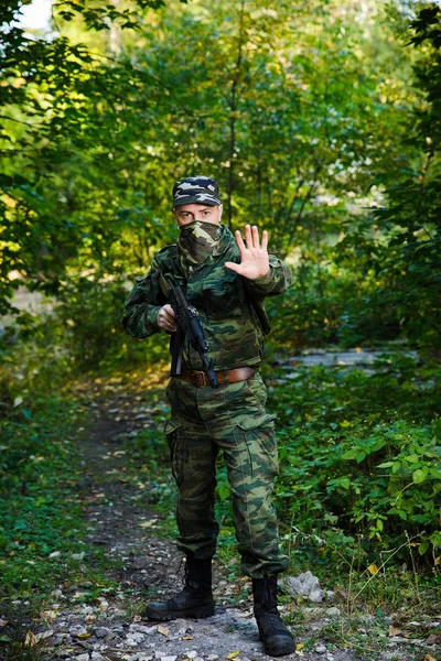 Ormandaki elle stop sinyali gösterilen asker. Kavram durdurmak. — Stok fotoğraf