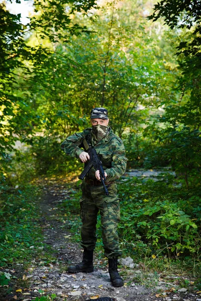 Soldaat of burgerwacht in camouflage met assault rifle Ak onderweg — Stockfoto