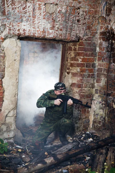 Soldaat of burgerwacht in camouflage met aanval geweer Ak gevechten in ruïnes — Stockfoto