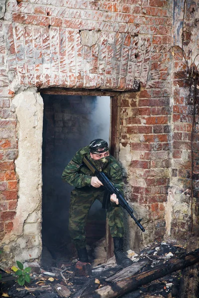 Soldaat of burgerwacht in camouflage met aanval geweer Ak gevechten in ruïnes — Stockfoto