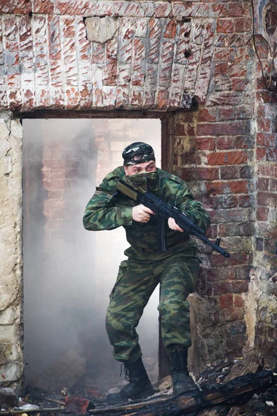 Żołnierz lub Milicjant w kamuflażu karabin szturmowy Ak walce w ruiny — Zdjęcie stockowe