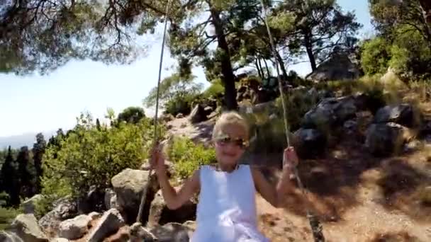 스윙에 금발 머리와 하얀 드레스에 귀여운 소녀. 그녀는 행복 하 고 카메라에 웃음 — 비디오