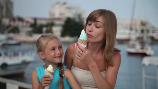 Mãe e filha comendo sorvete. Eles olhando para a câmera e sorrindo — Vídeo de Stock