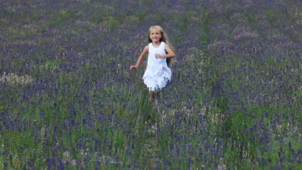 Linda chica ranchando a través del campo. Niño está en un vestido blanco — Vídeos de Stock