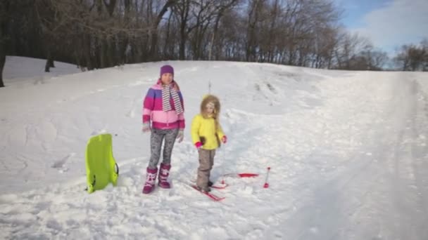 Happy family came to ride on a sled in the winter. They are looking at camera and smiling — Stock Video