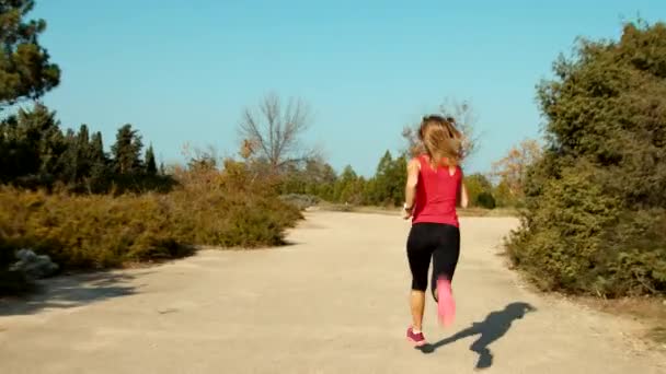 Nuori nainen juoksee puistossa — kuvapankkivideo