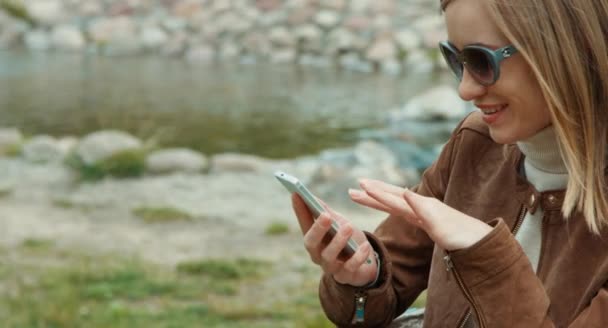 Closeup retrato jovem mulher adulta usando telefone celular e olhando para a câmera — Vídeo de Stock