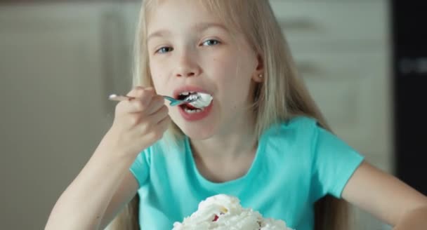 Портрет крупным планом девушки, поедающей клубнику со сливками — стоковое видео