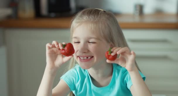 Γέλιο κορίτσι με δύο φράουλες dabbles — Αρχείο Βίντεο