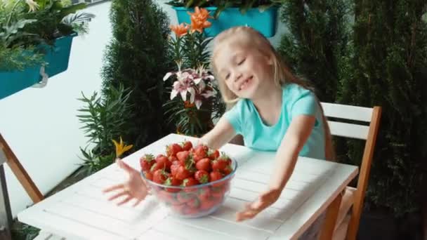 Girl with a big plate of strawberries looking at camera and smiling. Zooming — Stock Video