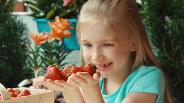 Muchacha retrato de cerca con un puñado de fresas. Ampliación — Vídeos de Stock