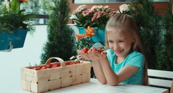 Menina com punhado de morangos oferecendo espectadores — Vídeo de Stock