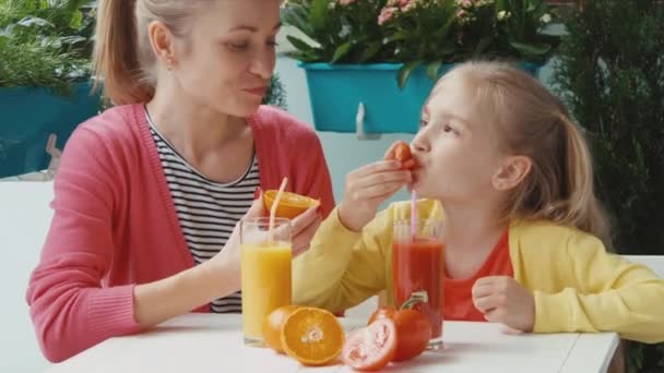 Famiglia che mangia pomodoro e arancia e guarda la telecamera. Zoomare — Video Stock