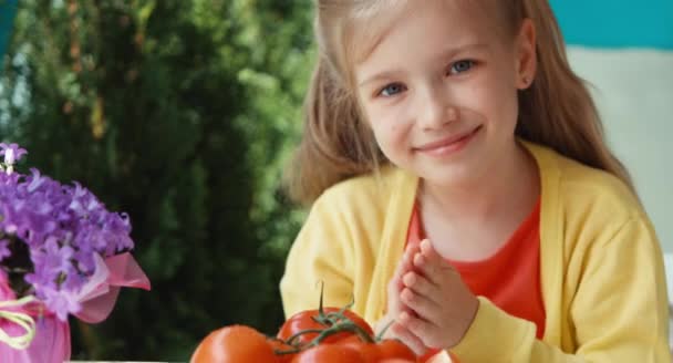 Plaka domates ile aşırı closeup portre sarışın kız. Yaşasın. Tamam. Kameraya gülen çocuk — Stok video