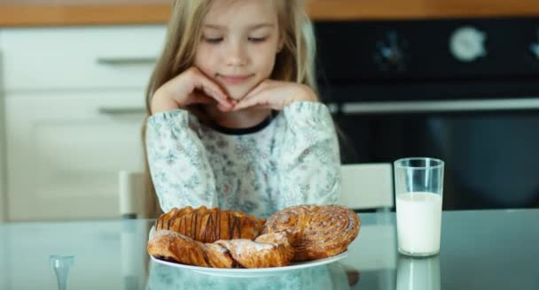 Flicka i pyjamas beundra sweet rullar i köket — Stockvideo