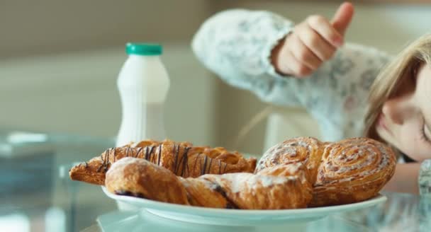 Kind bewundert süße Brötchen und blickt in Kamera — Stockvideo